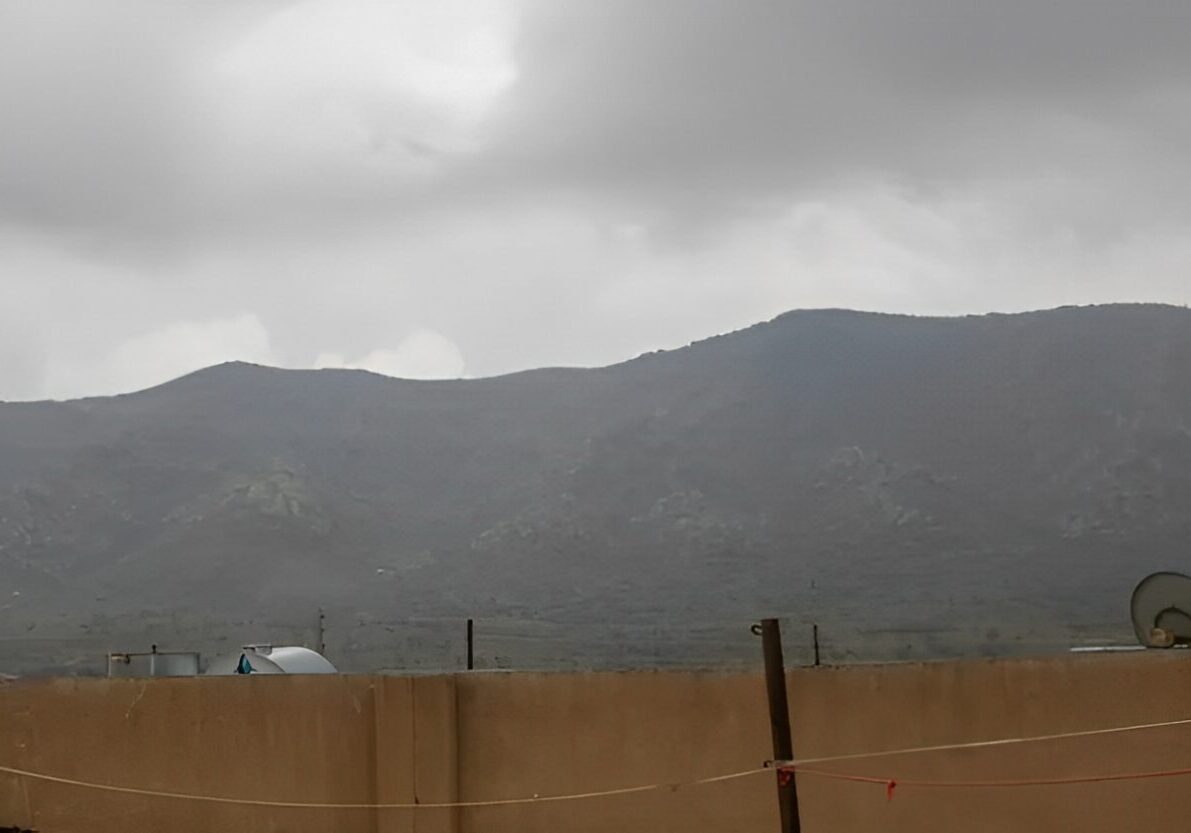 Cloudy sky over distant mountain range.
