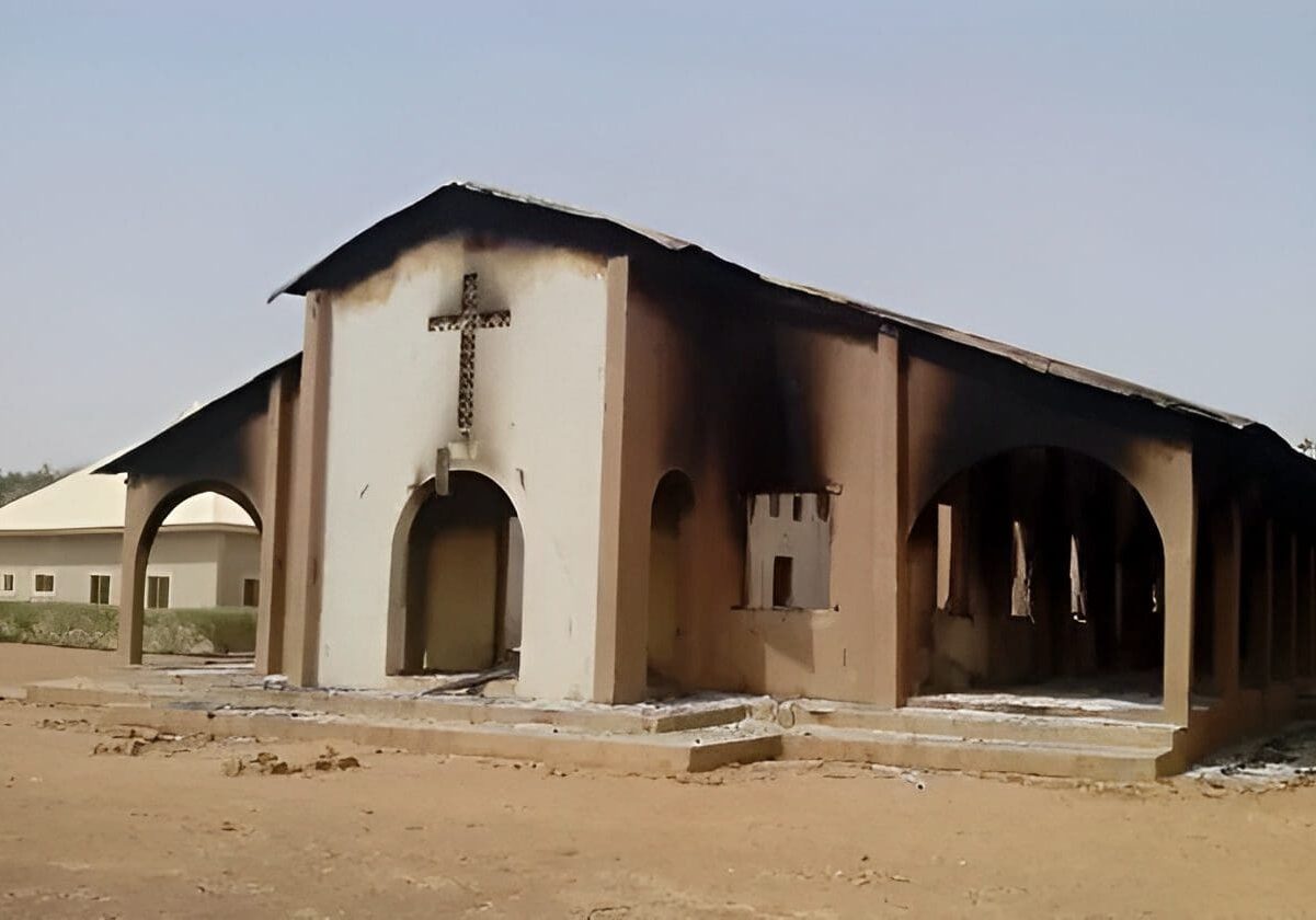 Burned church building with arched openings.